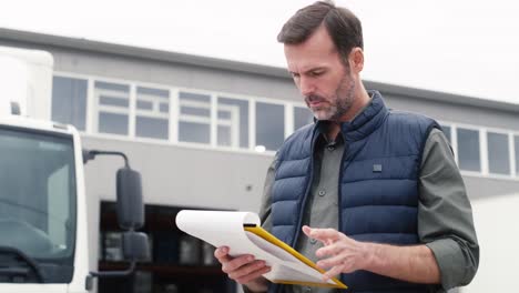Caucasian-mature-man-in-front-of-warehouse-with-documents.